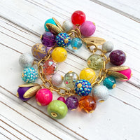 Colorful beaded bracelet for women. Assorted unique beads in a wide range for colors, texture, and shape wire wrapped on a solid and sturdy brass plated chain with lobster clasp.