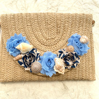 Straw woven clutch purse for women with removable strap. Embellished straw crossbody bag with seashells and fabric flower details.