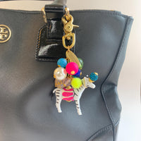 Colorful cute bag charm on a black handbag. Lenora Dame bag charms.