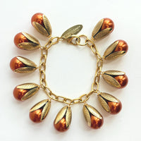 Gold chain bracelet with shiny pumpkin orange pearls encased in gold leaf bead caps. Lenora Dame bracelets handmade in the USA.