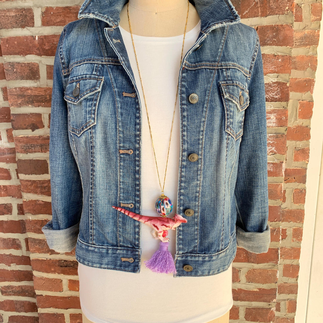 Dinosaur pendant necklace for women. Dinosaur charm hung on a long gold chain.