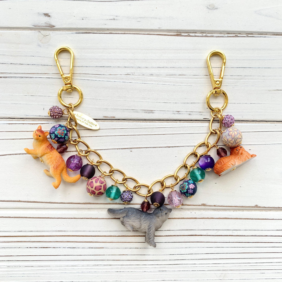 Cat bag charm with cat charms and a mix of purple and green beads on a gold chain. Cute bag chains for handbags. Purple bag cham.