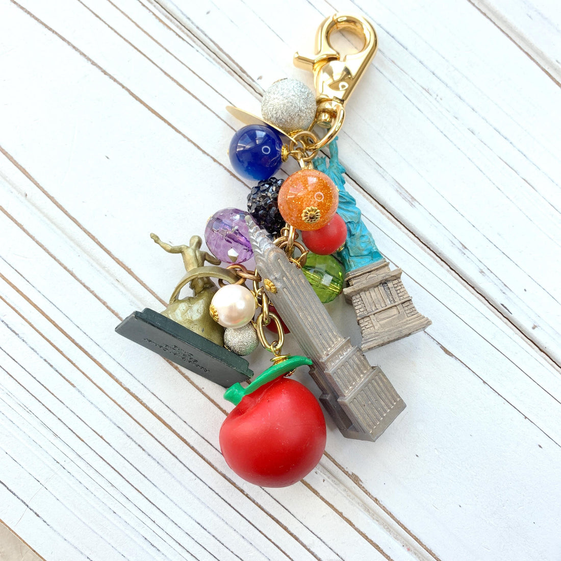 New York City bag charm . New York City keychain with colorful beads and statue of liberty charm, Prometheus charm, and Chrysler Building charm.
