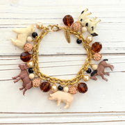 Gold chain charm bracelet with farm animal charms, pearls, peach rhinestone beads and brown faceted beads.
