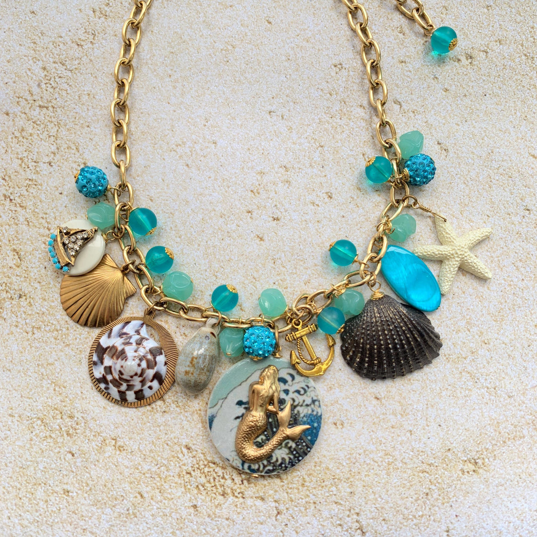 Mermaid charm necklace for vacation outfit ideas. Aqua blue beads, seashells, starfish, anchor charm and mermaid pendant necklace for summer.