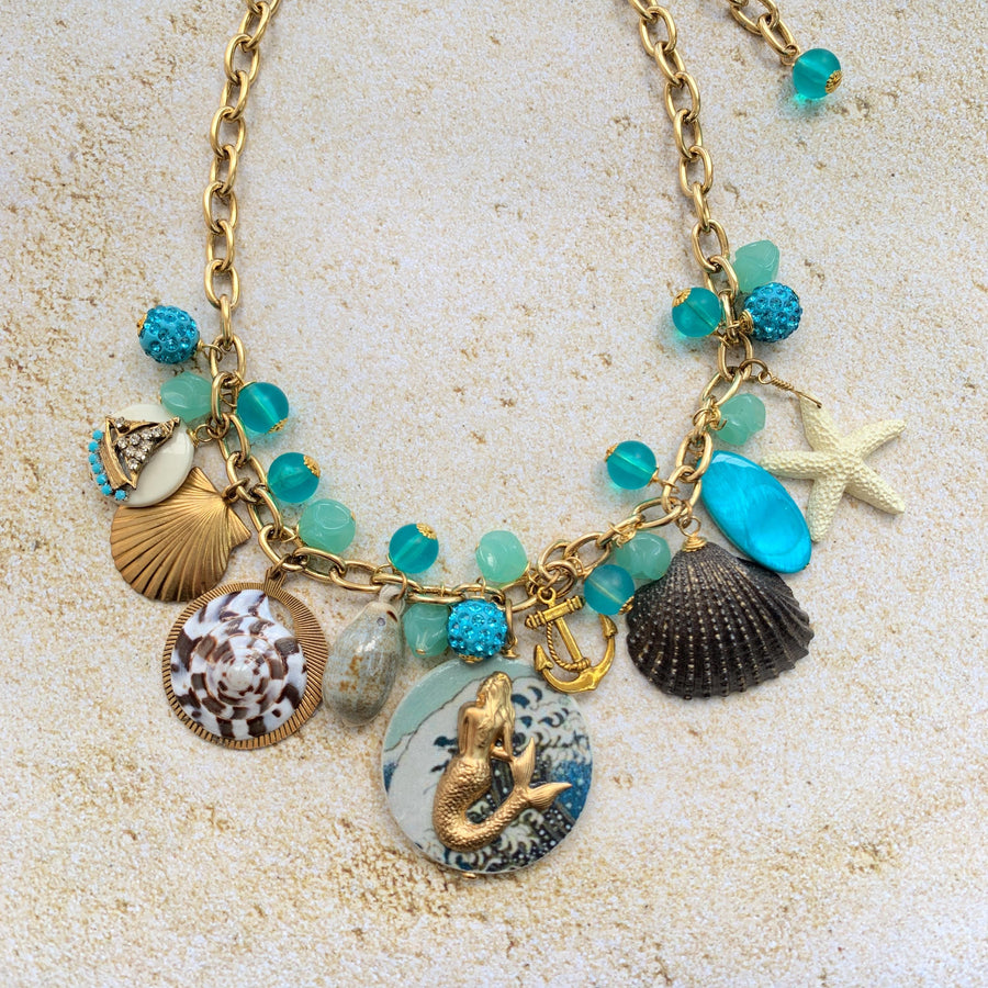 Mermaid charm necklace for vacation outfit ideas. Aqua blue beads, seashells, starfish, anchor charm and mermaid pendant necklace for summer.