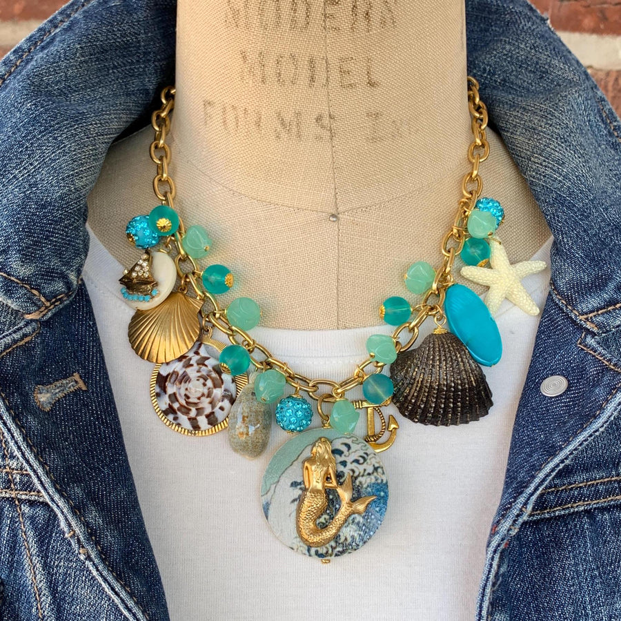 Mermaid charm necklace for vacation outfit ideas. Aqua blue beads, seashells, starfish, anchor charm and mermaid pendant necklace for summer.