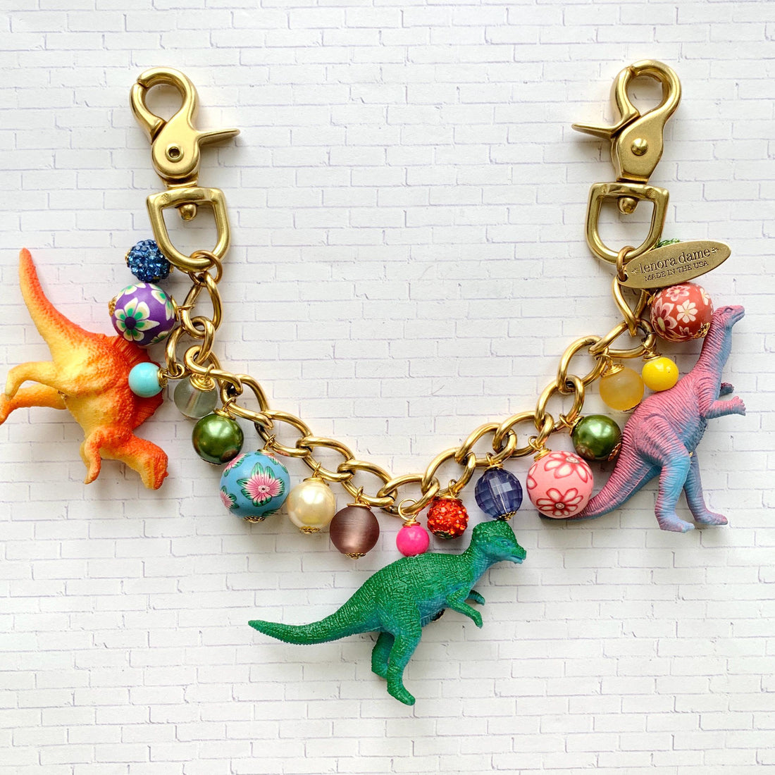 Lenora Dame dinosaur bag chain. Cute chain bag charm for handbag with dinosaurs and colorful beads.