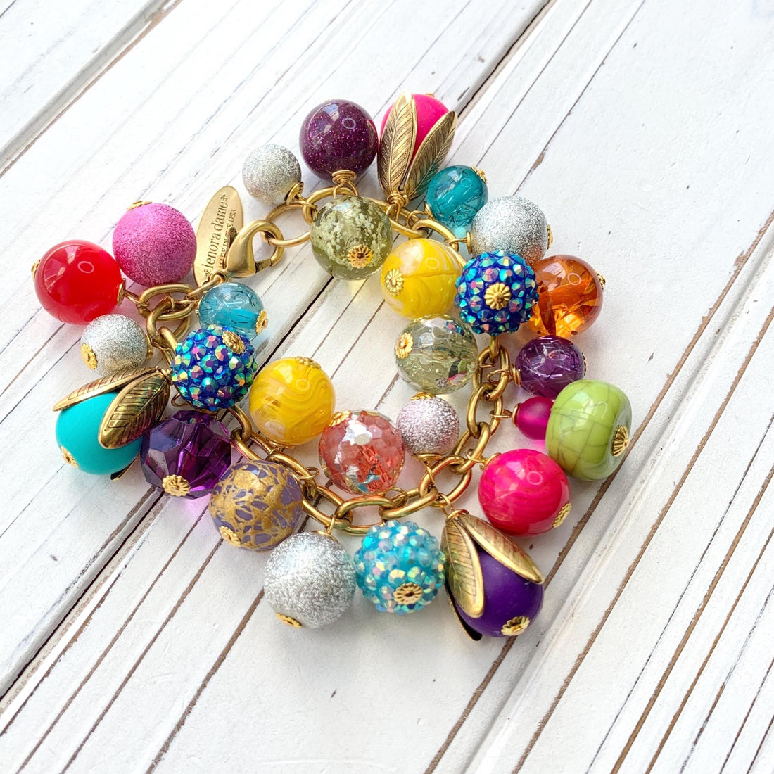 Colorful beaded bracelet for women. Assorted unique beads in a wide range for colors, texture, and shape wire wrapped on a solid and sturdy brass plated chain with lobster clasp.