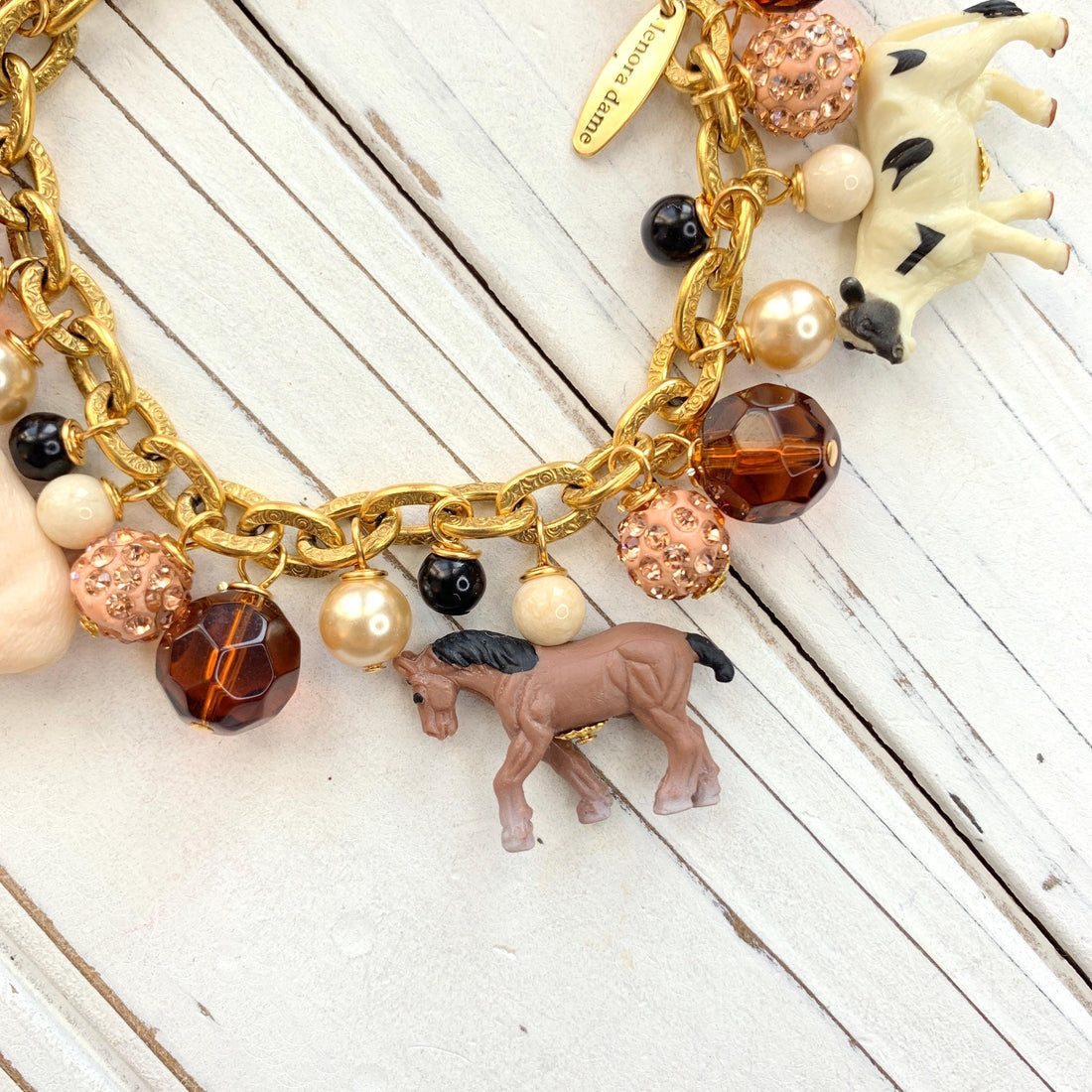 Miniature horse charm on a gold chain charm bracelet.