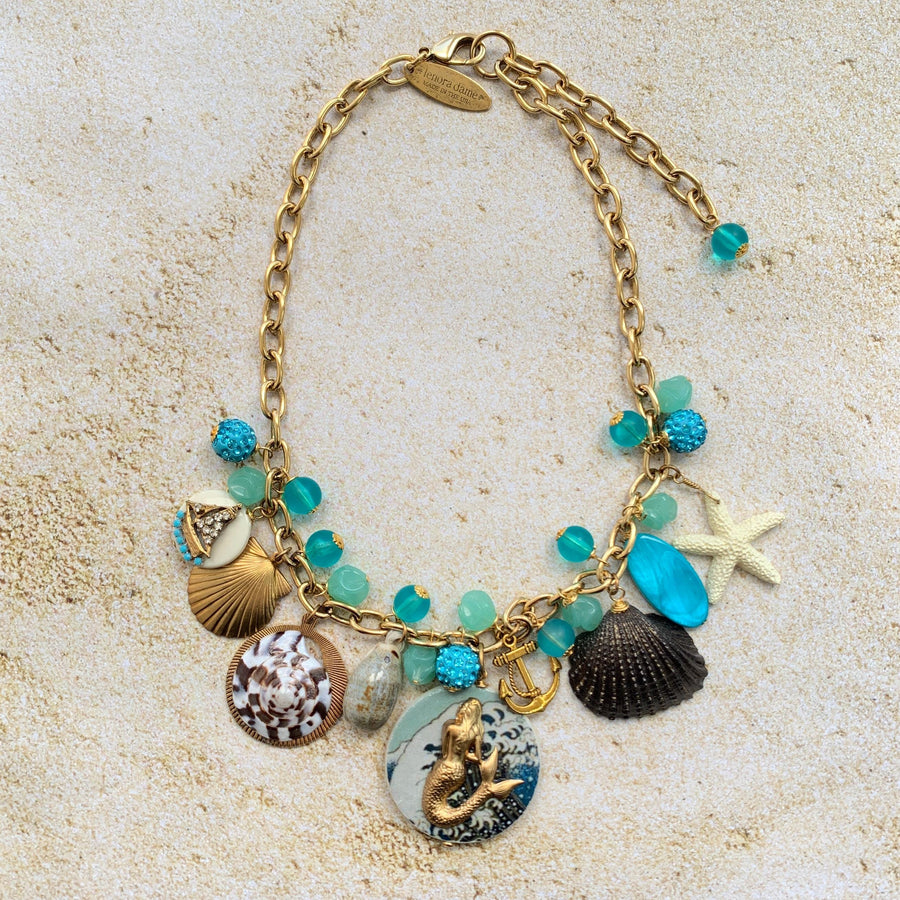 Mermaid charm necklace for vacation outfit ideas. Aqua blue beads, seashells, starfish, anchor charm and mermaid pendant necklace for summer.