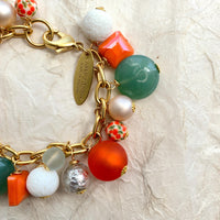 Lime green beads, orange beads, white beads, silver beads wire wrapped on a gold chain.