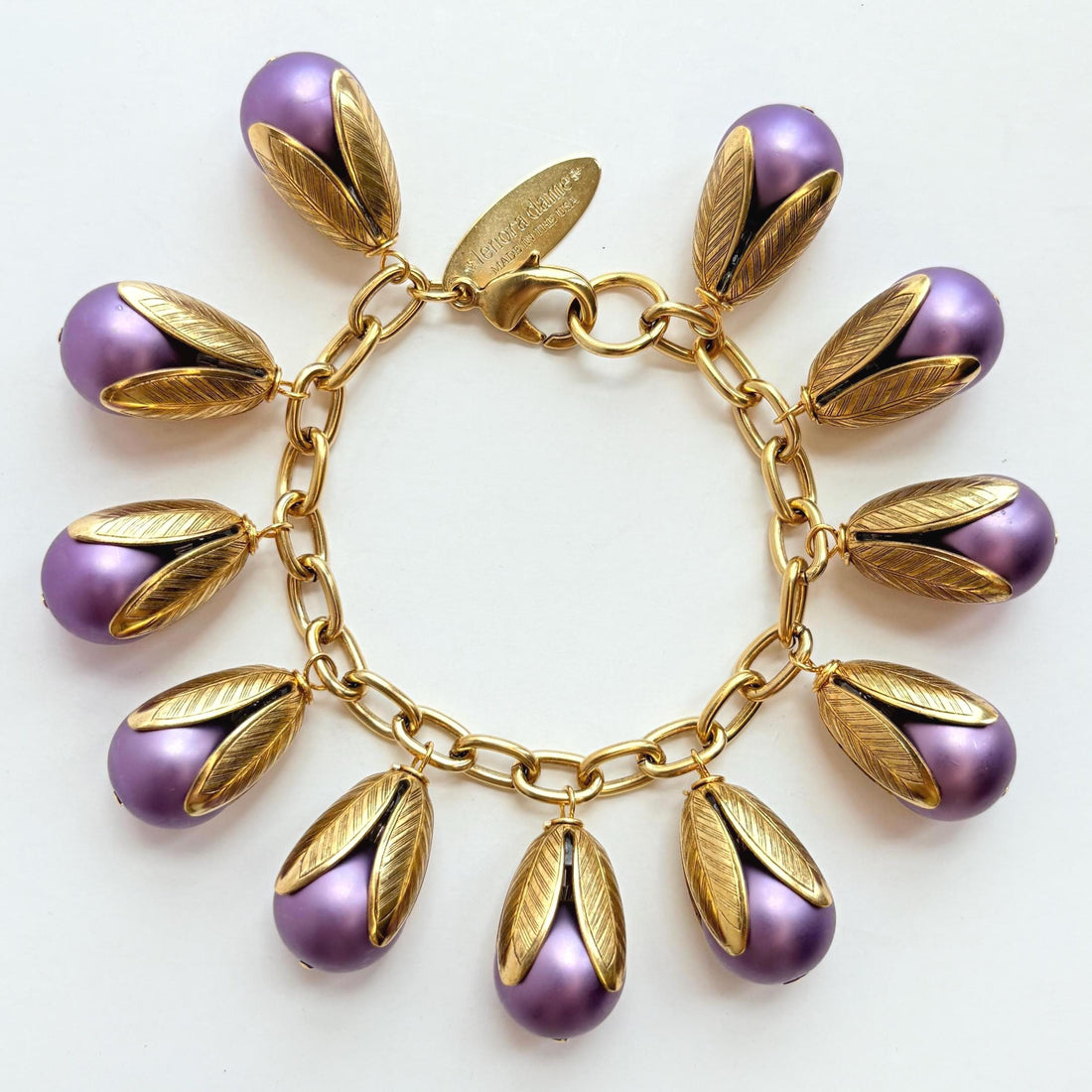 Gold chain bracelet with matte finish purple pearls encased in gold leaf bead caps. Lenora Dame bracelets handmade in the USA.