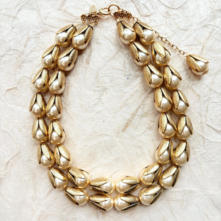 Two strand gold necklace with cream pearls encased in gold leaf bead caps. Lenora Dame necklace.